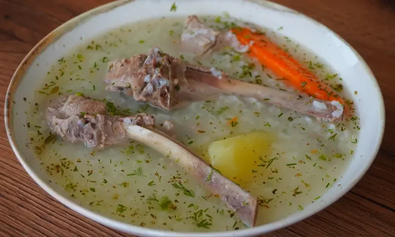 Caldo de cordero con arroz, papa, zanahoria y culantro servido caliente en plato hondo