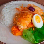 Escabeche de pollo: Un plato tradicional peruano con pollo, cebolla, tomate y ají amarillo.