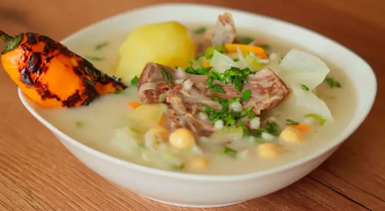 Un plato humeante de Charqui Caldo, con carne, papas, garbanzos y verduras en un caldo sabroso.