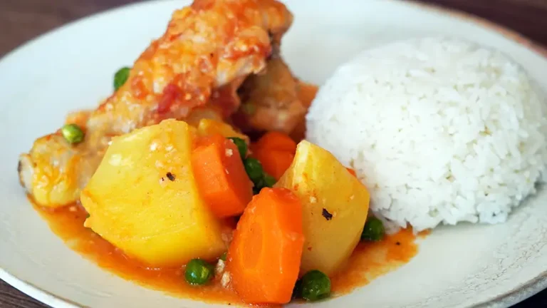 Plato de Estofado de Pollo Peruano servido con papas y arroz