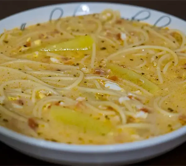 Sopa de leche con fideos, papas y huevo deshecho servida caliente y cremosa