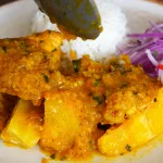 Delicioso Pollo a la Chiclayana con yuca frita y arroz blanco. Receta tradicional peruana.