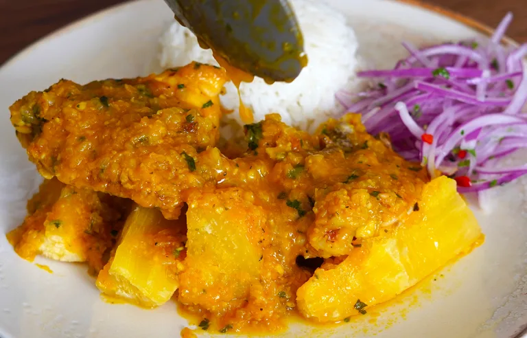 Delicioso Pollo a la Chiclayana con yuca frita y arroz blanco. Receta tradicional peruana.
