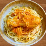 Plato de tallarines rojos con pollo