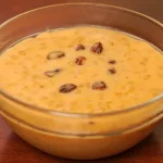 Mazamorra de trigo con leche, un postre tradicional peruano decorado con pasas y canela.