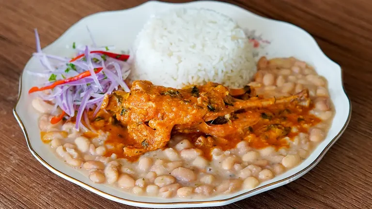 Cabrito a la Norteña servido con arroz y frijoles, plato típico de la cocina peruana
