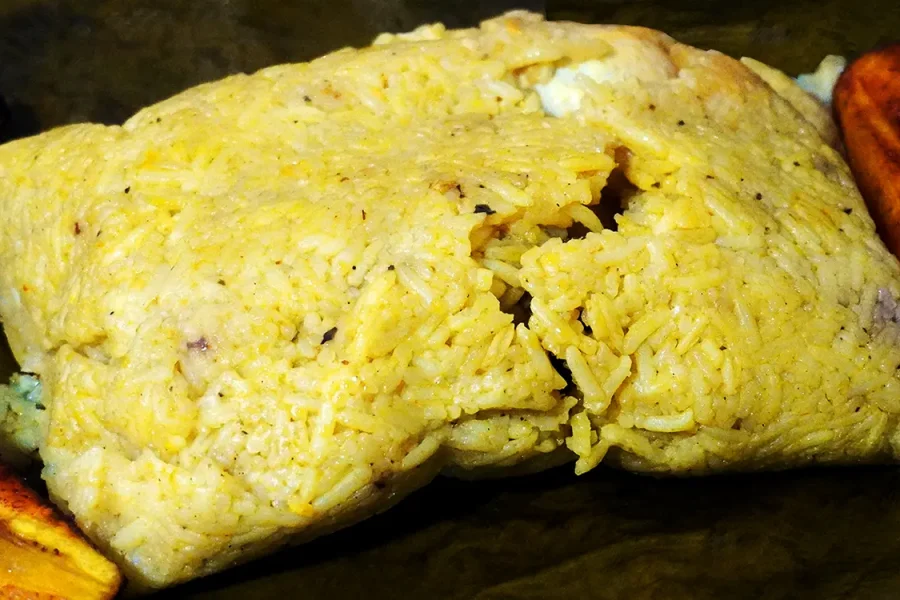 Juane de gallina tradicional envuelto en hoja de bijao servido con arroz y huevo duro, receta típica de la Amazonía peruana
