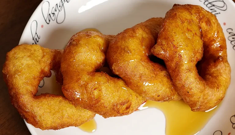 Picarones Peruanos con miel casera servidos en un plato - Postre tradicional peruano.