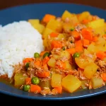 Guiso de Atún Peruano con papas y alverjas servido en un plato caliente