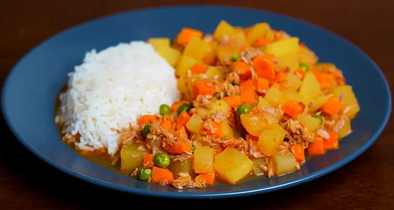 Guiso de Atún Peruano con papas y alverjas servido en un plato caliente