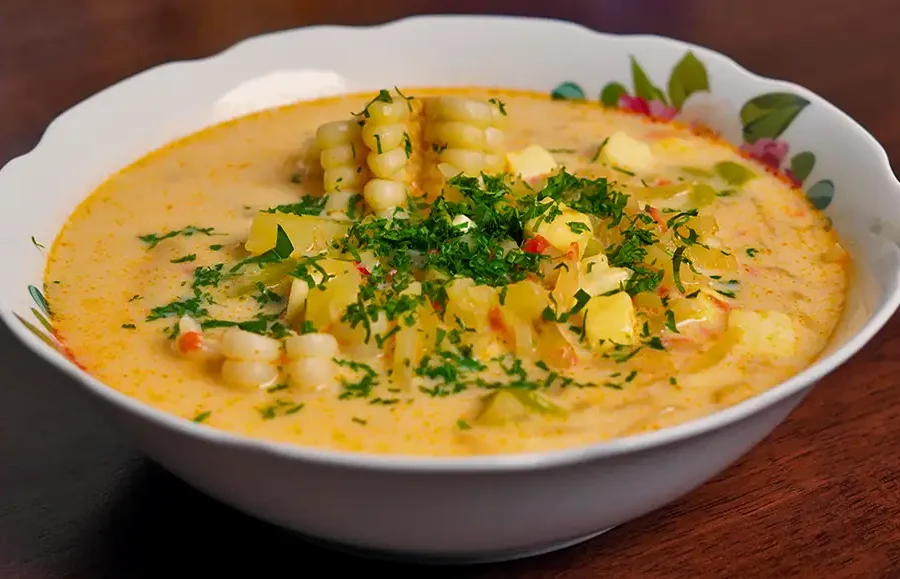 Plato de chupe de olluco peruano servido caliente con queso fresco, huevo y perejil picado