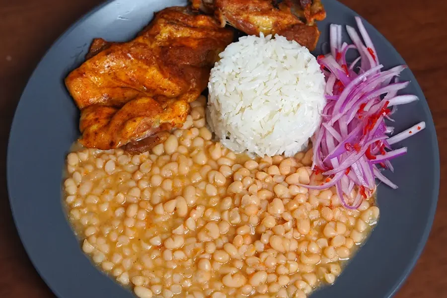 Plato de frejoles panamito acompañados de pollo frito, arroz blanco y ensalada criolla