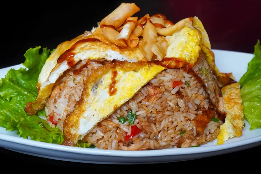 Chaufa de pescado peruano con arroz frito y trozos de pescado dorado