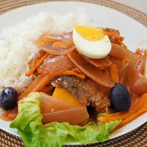 Plato de escabeche de pescado bonito con camote y huevo duro.