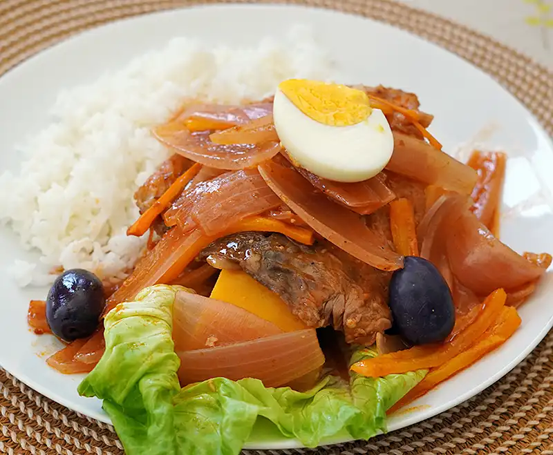 Plato de escabeche de pescado bonito con camote y huevo duro.